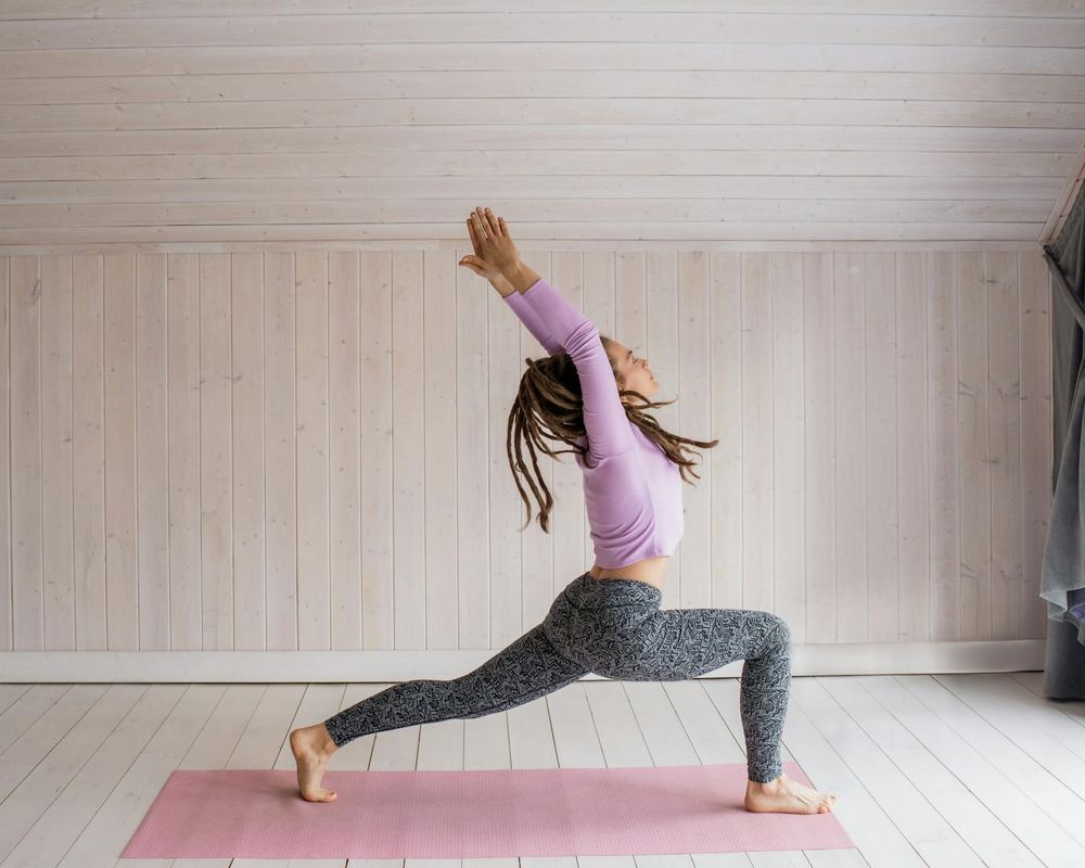 Person practicing yoga flow in a bright modern room.